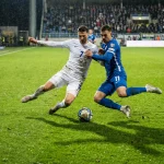 Futbalisti na ihrisku počas medzinárodného zápasu v modernom štadióne