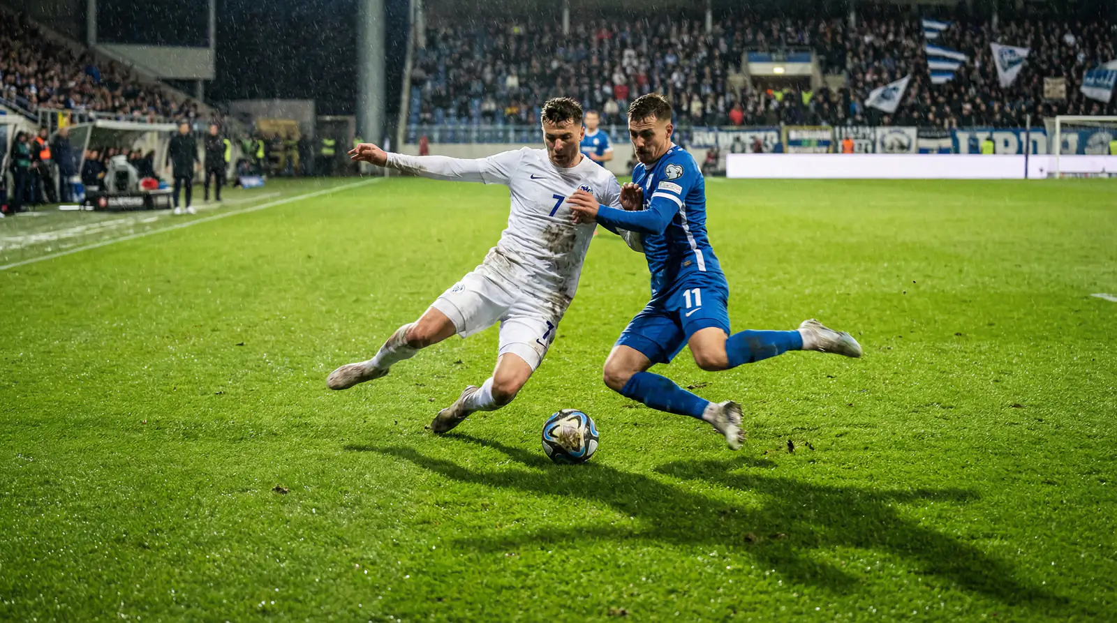 Futbalisti na ihrisku počas medzinárodného zápasu v modernom štadióne