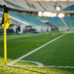 Zelený futbalový trávnik s bielymi čiarami pred zápasom na veľkom štadióne
